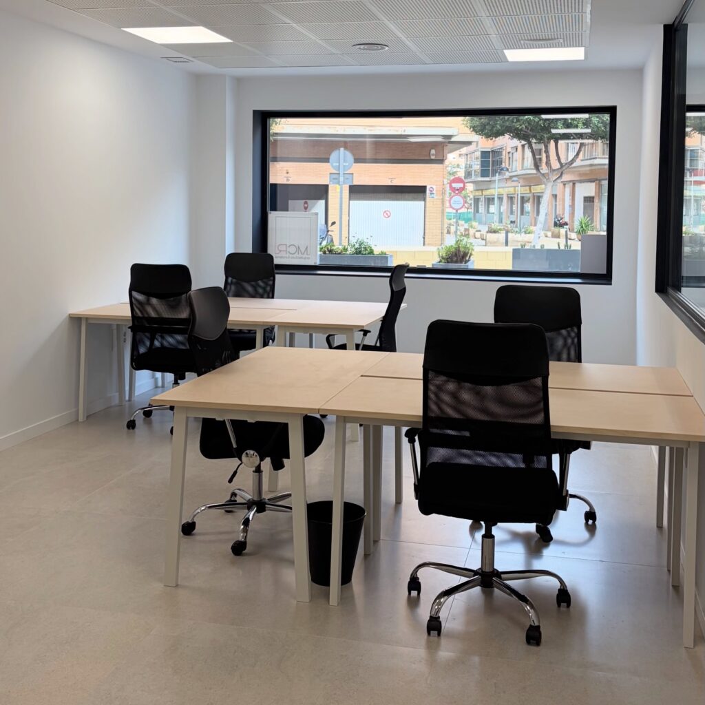 Despacho privado con varias mesas y sillas en el coworking Lola Coworking en Calle Lima, Almería